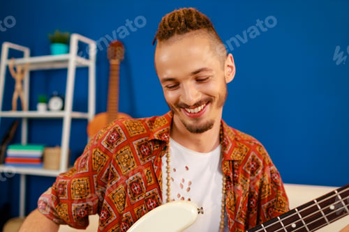 Preview: Young caucasian man with dreadlocks playing electric guitar in his room