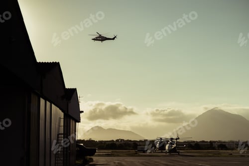 Preview: Hangar with helicopters at sunset.