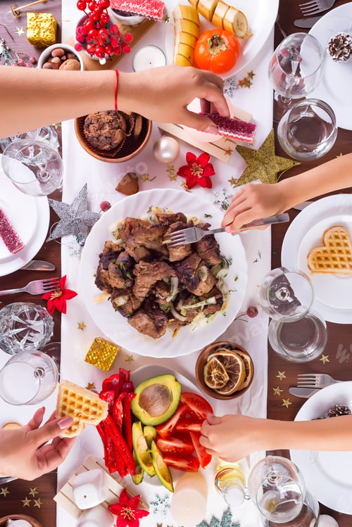 Preview: Christmas table setting with food on a plate, mom and child hands handing food and decoration on
