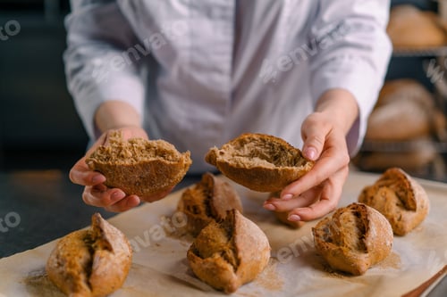 Preview: baker showing hot cut freshly baked crispy and puffy bread bun bakery
