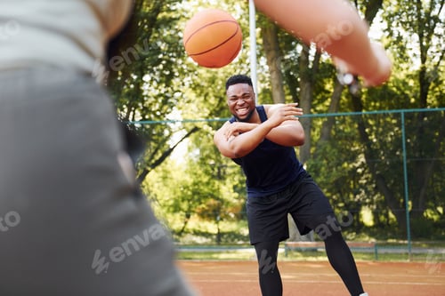 Preview: African american man with girl plays basketball on the court outdoors