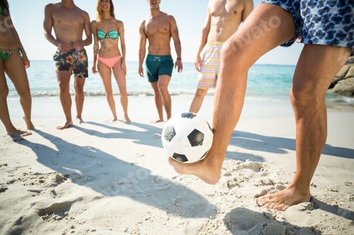 Preview: Man balancing soccer ball against friends