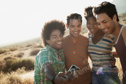 Preview: A group of friends, men and women, heads together posing for a selfy in the heat of the day.