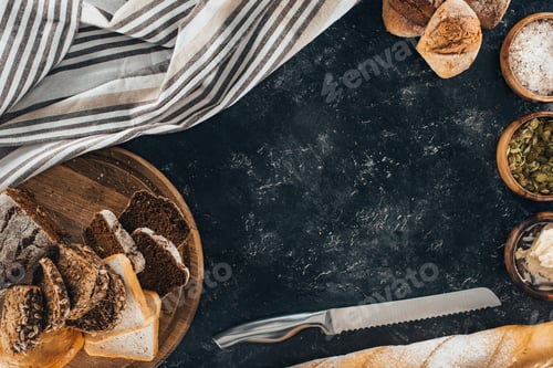 Preview: top view of fresh homemade bread and knife on black slate board