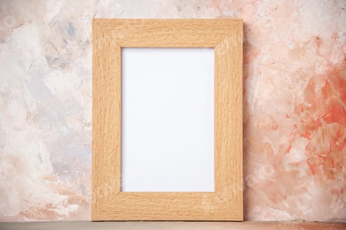 Preview: Close up view of empty brown wooden photo frame hanging on soft colors wall with free space