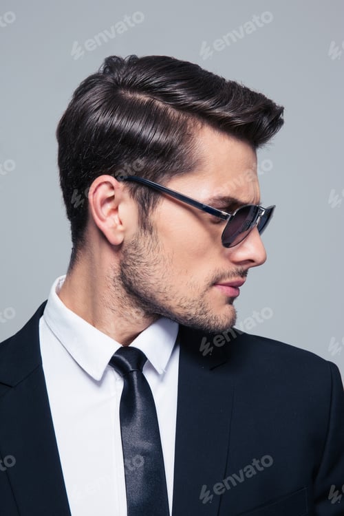 Preview: Businessman in sunglasses looking away