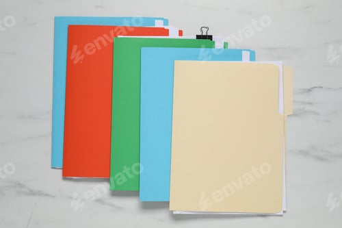 Preview: Many documents in folders with binder clip on white marble table, top view