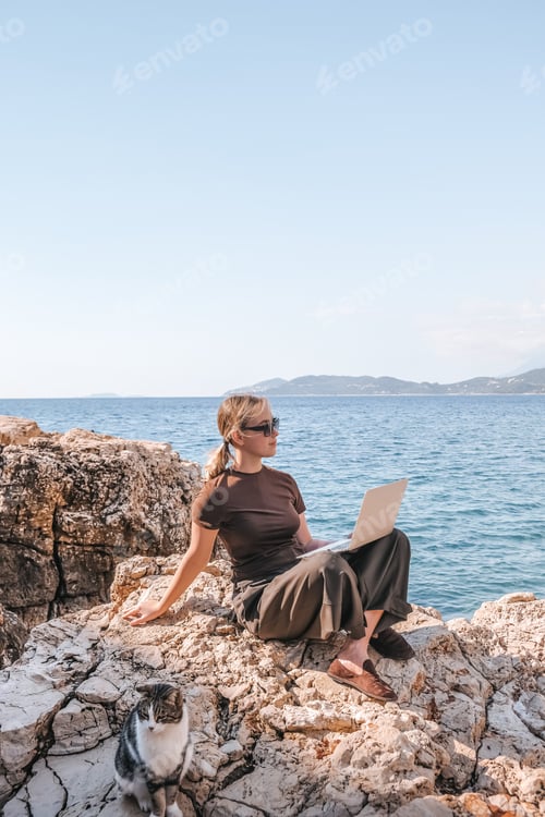 Preview: Freelance woman working remotely laptop stunning ocean cliff view. digital nomadism,remote work