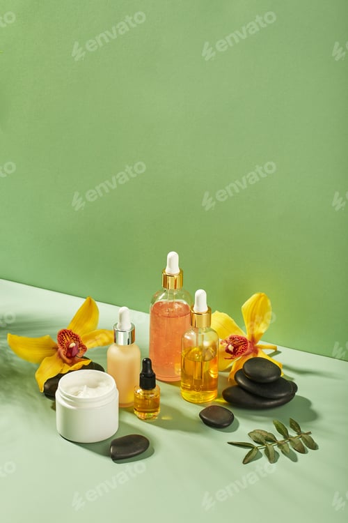 Preview: Cosmetic care products in glass bottles with orchid flowers - serums, cream, gel, oils. Concept for