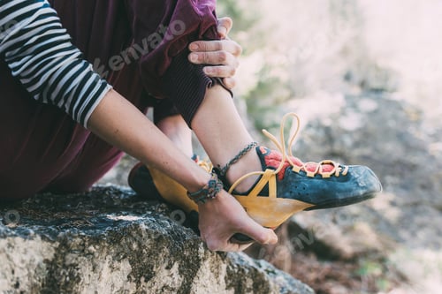 Preview: Climber readying for the climb with a closeup on hands and feet