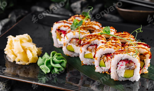 Preview: Fresh sushi rolls with eel and avocado being served on black plate