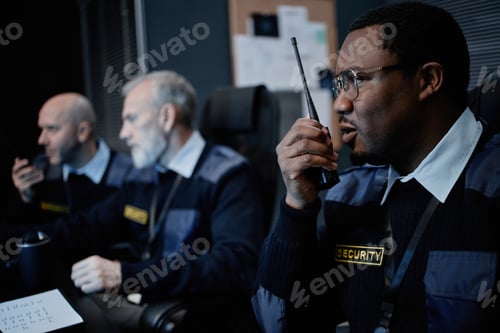 Preview: Middle Aged Black Man Communicating with Walkie Talkie in Security Office