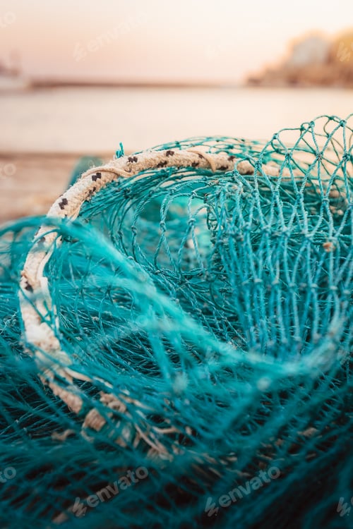 Preview: Artistic close up of turquoise fishing nets arranged on the harbor