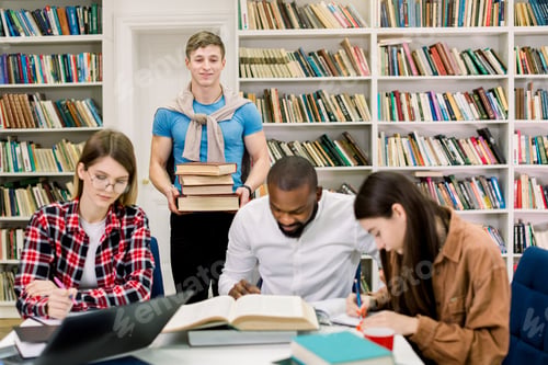 Preview: Multiethnic group of young people, students, studying together at the table, reading books. Young