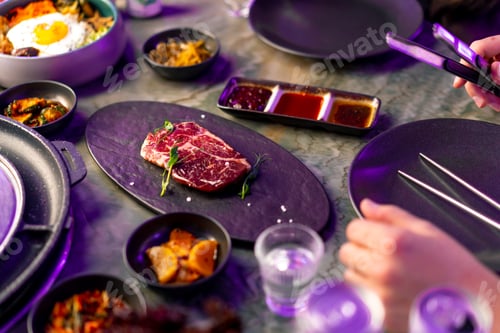 Preview: close-up top view delicious appetizing juicy piece of raw meat on table with sauces on appetizers