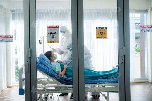 Preview: Medical Staff Treating Patient in Hospital Isolation Room