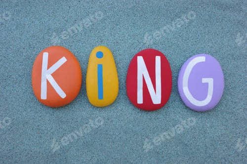 Preview: King word composed with multi colored stone letters over green sand