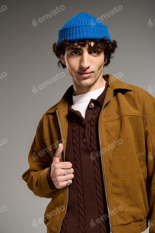 Preview: Stylish young man showcases modern fashion with confidence in a studio setting