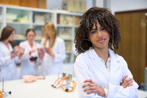 Preview: Confident medical student posing with crossed arms in university lab