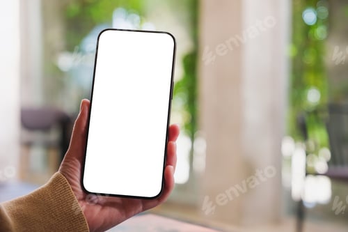 Preview: Mockup image of a woman holding and using mobile phone with blank desktop in cafe