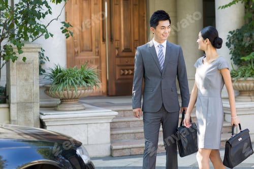 Preview: Young couple walking together with briefcases