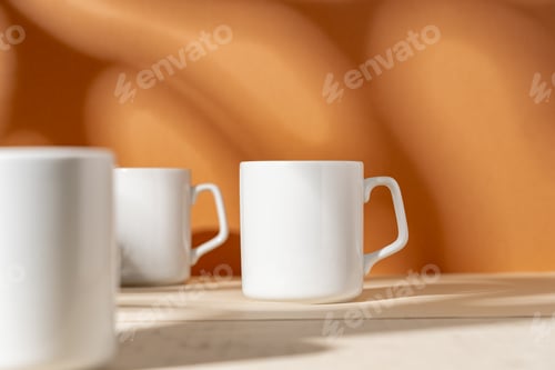 Preview: White ceramic mugs on peach background with shadows