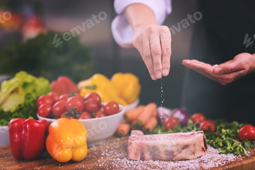 Preview: Chef putting salt on juicy slice of raw steak