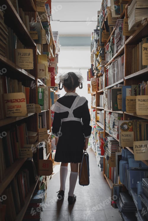 Preview: A girl in a school uniform walks through the library