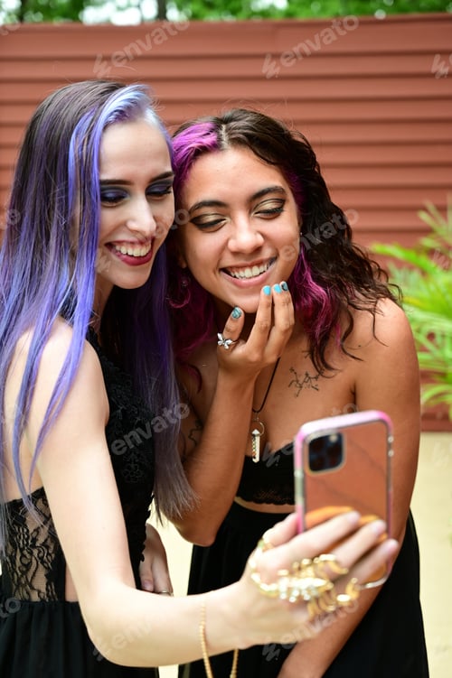Preview: Pretty millennials with purple and magenta hair, laughing taking selfie