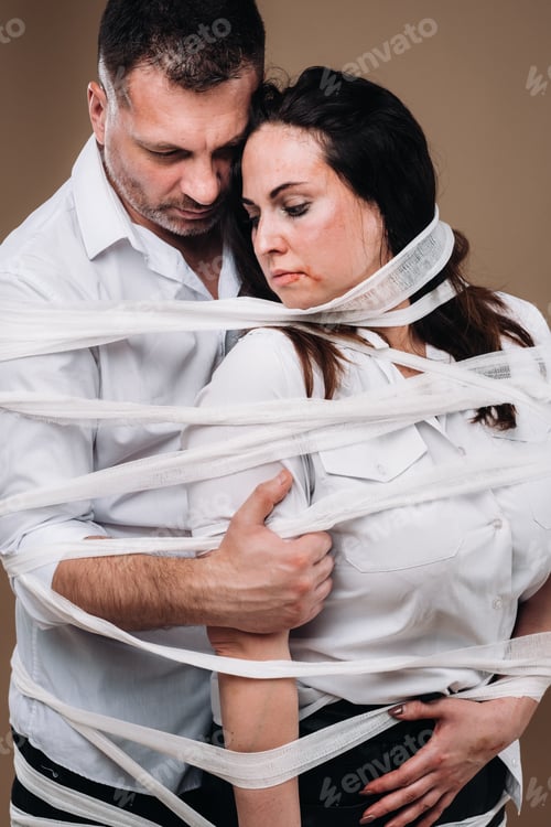 Preview: An aggressive man embraces a battered woman and is wrapped in bandages together. Domestic violence