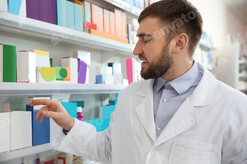Preview: Professional pharmacist near shelves in modern drugstore