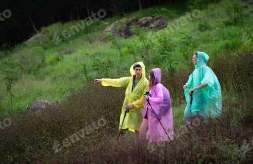 Preview: Group of friends in raincoats with backpacks on a hike in the forest, Prepare to hiking