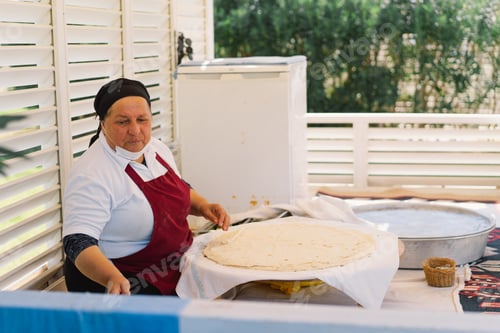 Preview: Woman Preparing Traditional Flatbread in Outdoor Market During Daytime