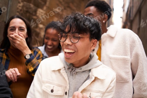 Preview: Asian guy with a Group of happy multiethnic friends laughing. People having fun outdoor