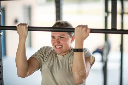 Preview: Determined female soldier doing pull ups at military air force base