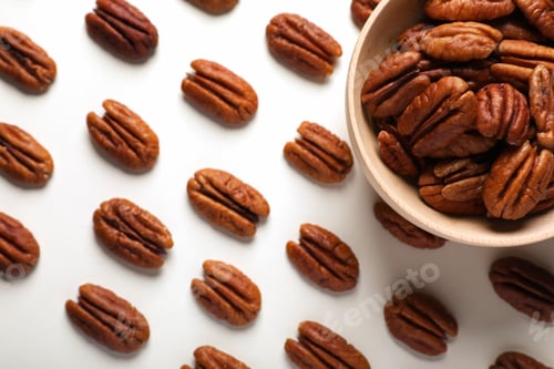 Preview: Delicious fresh pecan nuts and bowl on white background, flat lay