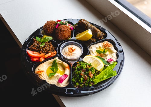 Preview: Healthy eating food Mediterranean dish with hummus, lemon, lentils, falafel, and grape leaves