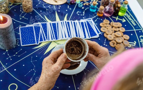 Preview: A fortune teller reads fortunes on coffee grounds. Selective focus.