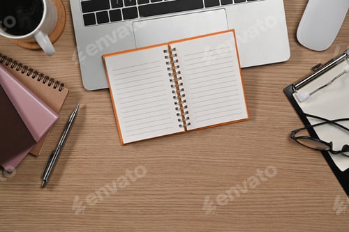 Preview: Top view laptop computer, coffee cup, notebook and glasses on wooden table. Simple workplace.