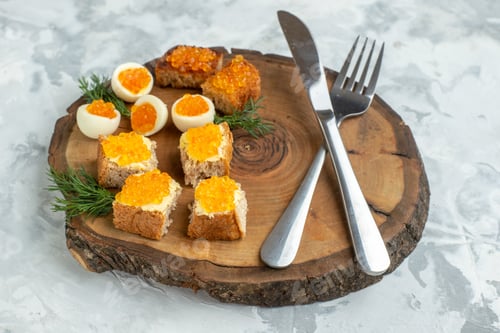 Preview: front view tasty caviar sandwiches with boiled eggs and cutlery on wooden board white background
