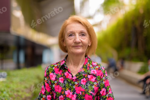 Preview: Portrait of a senior woman thinking outdoors during summer