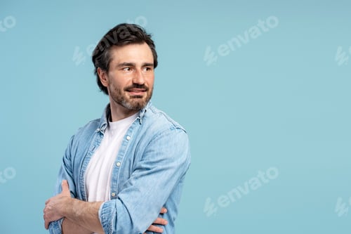 Preview: Confident entrepreneur looking away with crossed arms on blue background