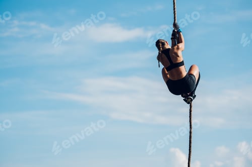 Preview: Fit female partake in an obstacle course race during which climbing a rope