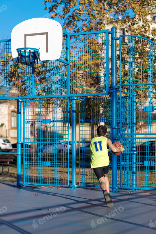 Preview: Teenage playing basketball on an outdoors court
