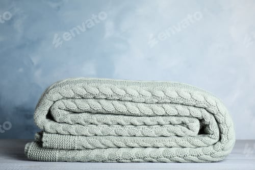 Preview: Neatly Folded Knit Blanket on a Wooden Surface