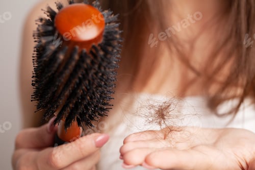Preview: Young woman with comb worried about hair loss