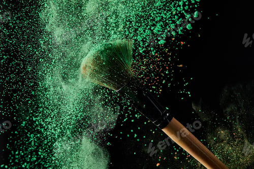 Preview: cosmetic brush with green powder explosion on black background