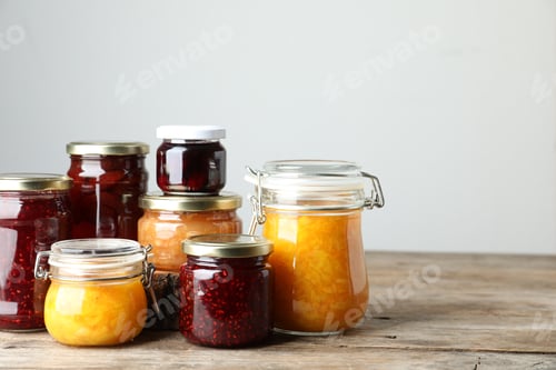 Preview: Jars with different jams on wooden table