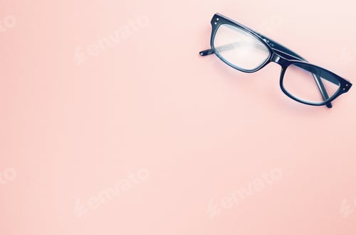Preview: Top view of oval eyeglasses with a blue frame on a pink surface