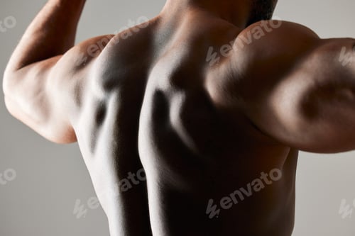 Preview: Studio shot of a unrecognizable male flexing his back muscles against a grey background
